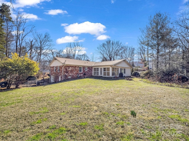 view of front of house featuring brick siding, a front yard, and fence