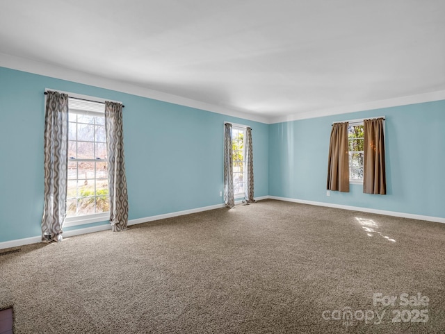 unfurnished room featuring carpet, visible vents, and baseboards