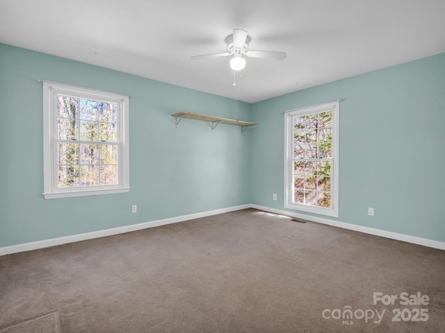 carpeted empty room featuring visible vents, baseboards, and a ceiling fan