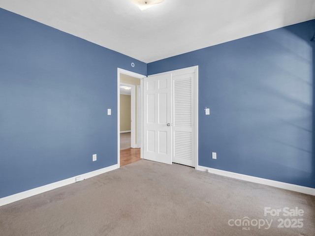 unfurnished bedroom featuring a closet, carpet, and baseboards