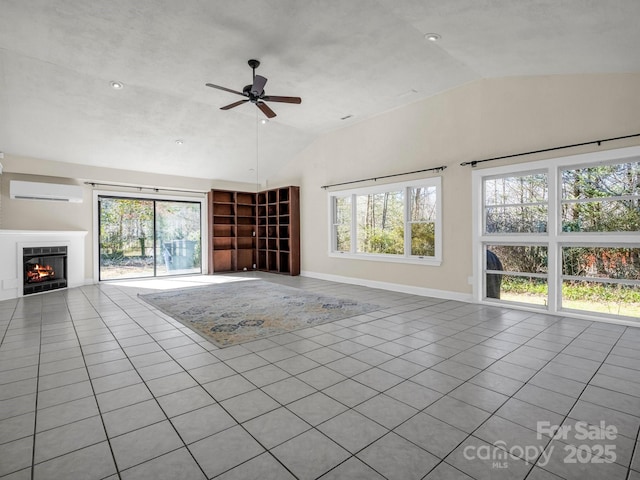 unfurnished living room with lofted ceiling, an AC wall unit, a healthy amount of sunlight, and tile patterned floors