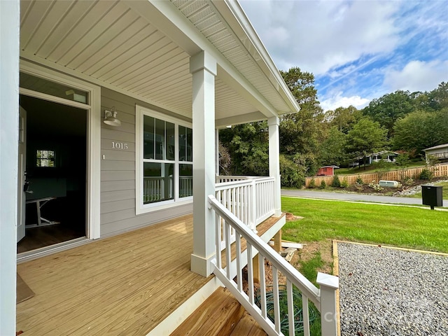 wooden deck with a yard and a porch