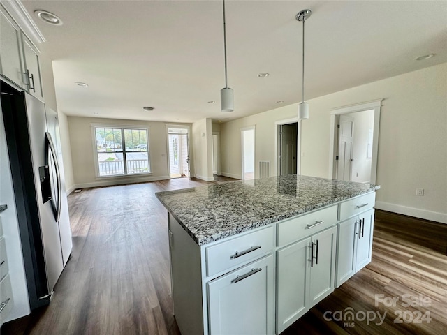 kitchen featuring a center island, white cabinets, stainless steel fridge, light stone countertops, and dark hardwood / wood-style flooring