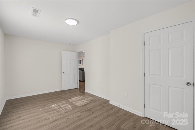 spare room featuring wood-type flooring