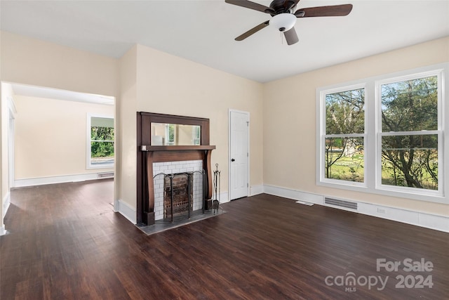 unfurnished living room featuring ceiling fan, dark hardwood / wood-style floors, and a brick fireplace