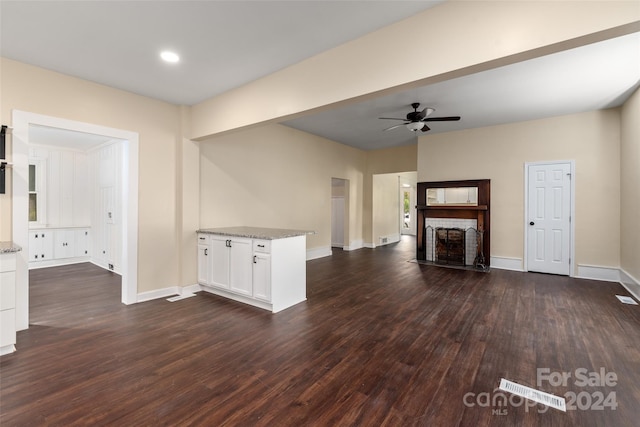 unfurnished living room featuring ceiling fan and dark wood-type flooring