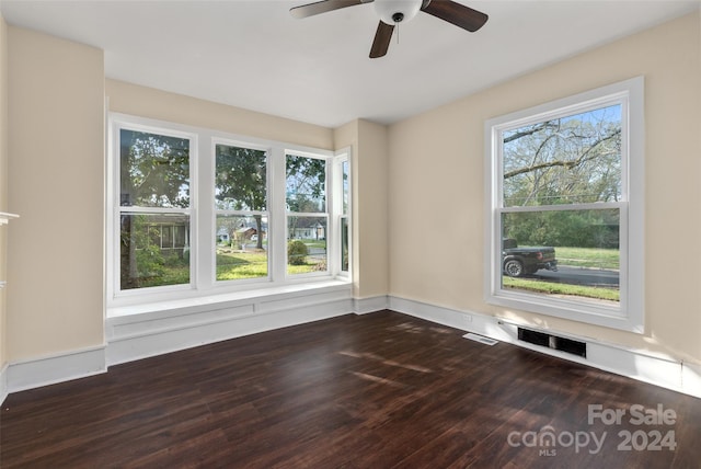 unfurnished room with dark hardwood / wood-style flooring, a wealth of natural light, and ceiling fan