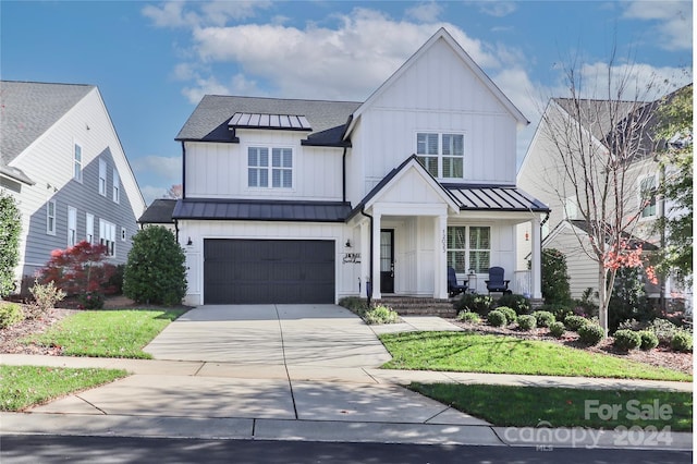 modern farmhouse with a front yard and a garage