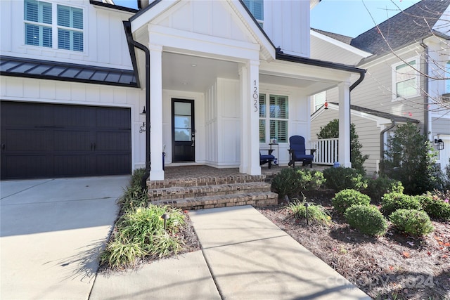 doorway to property featuring a porch and a garage