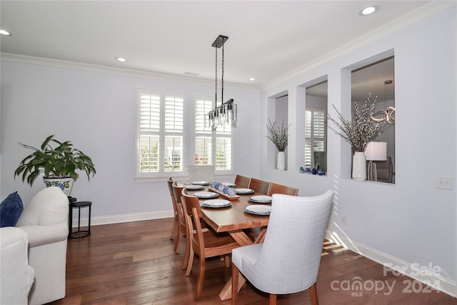 dining area featuring crown molding, dark wood-type flooring, and a notable chandelier