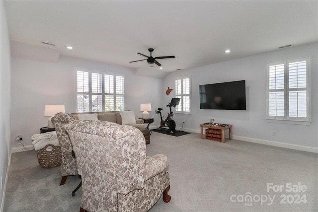 carpeted living room with ceiling fan and a wealth of natural light