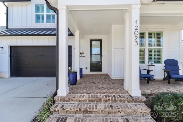 entrance to property featuring a garage and a porch