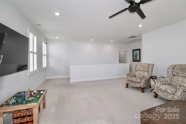 living area with ceiling fan and light carpet