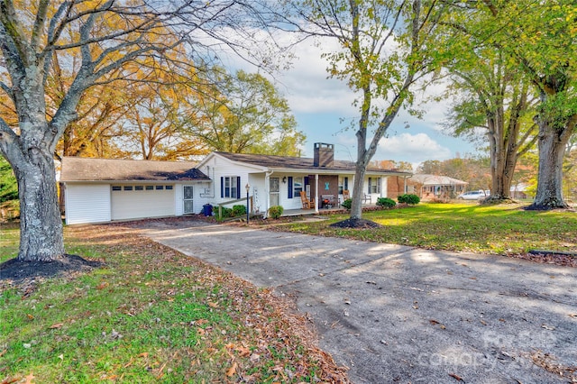 ranch-style home featuring a porch, a garage, and a front yard