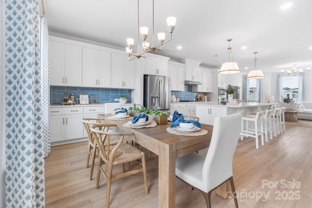 dining room featuring an inviting chandelier, recessed lighting, and light wood finished floors