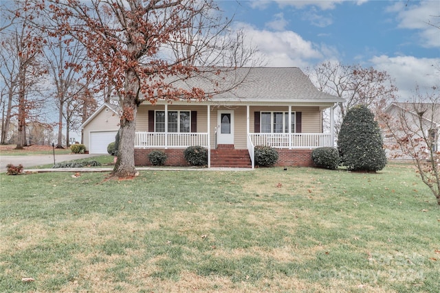 single story home with an outbuilding, covered porch, a front yard, and a garage