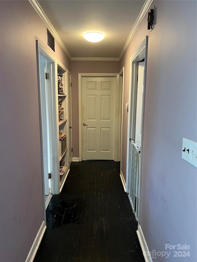 hallway featuring built in shelves, dark hardwood / wood-style flooring, and crown molding