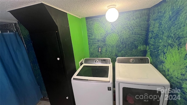 laundry room featuring washer and dryer and a textured ceiling