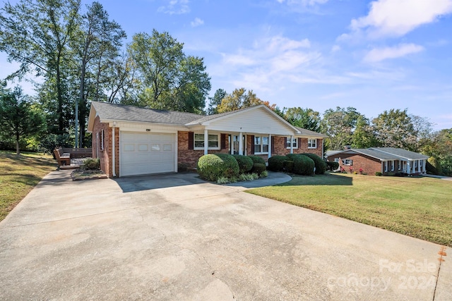 ranch-style home featuring a front lawn and a garage