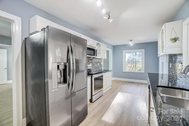 kitchen with white cabinets, backsplash, sink, and appliances with stainless steel finishes