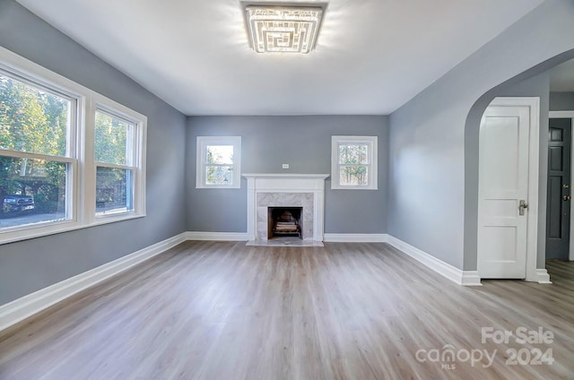 unfurnished living room with light wood-type flooring and a fireplace