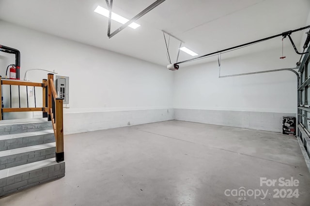 garage with electric panel and a garage door opener