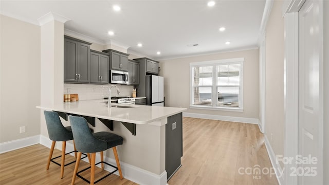 kitchen with sink, gray cabinetry, a breakfast bar area, backsplash, and white refrigerator