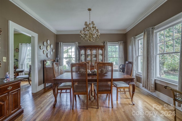 dining room featuring light hardwood / wood-style flooring, a chandelier, and ornamental molding