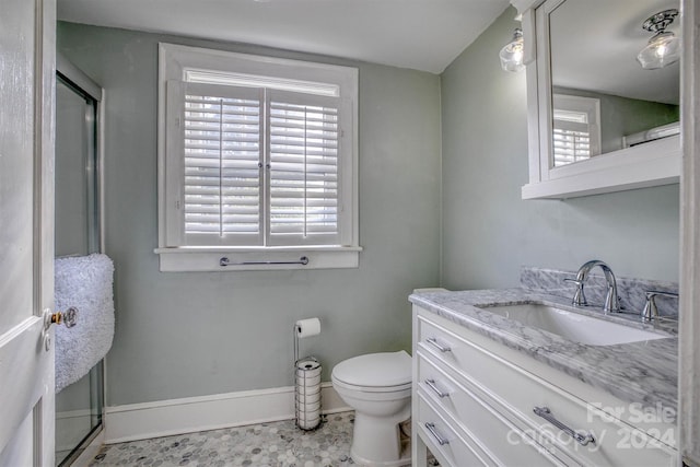 bathroom with tile patterned floors, vanity, a shower with shower door, and toilet