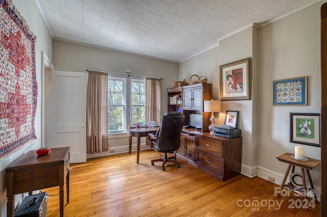 office area featuring light wood-type flooring and crown molding