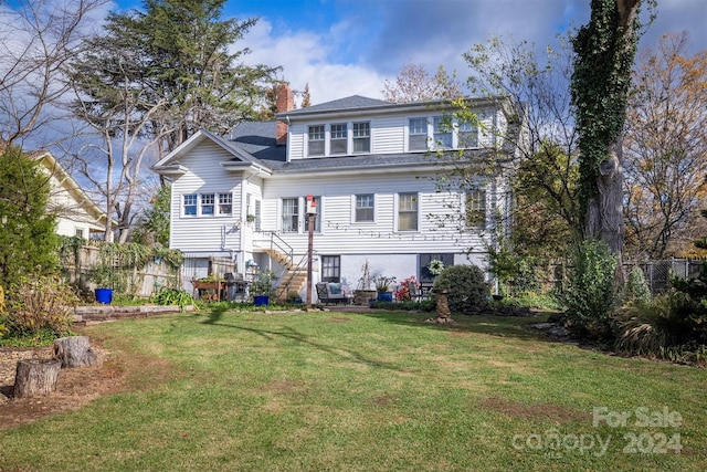 rear view of property featuring a lawn