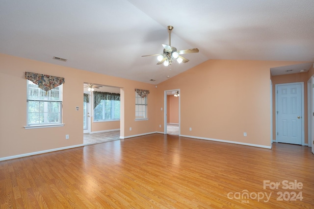 unfurnished room with ceiling fan, light wood-type flooring, and vaulted ceiling