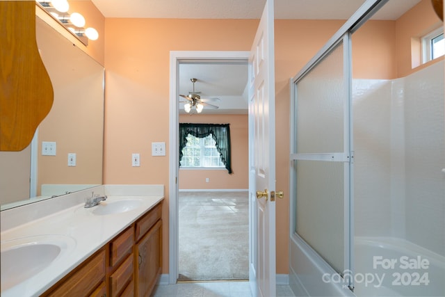 bathroom featuring ceiling fan, shower / bath combination with glass door, a textured ceiling, and vanity