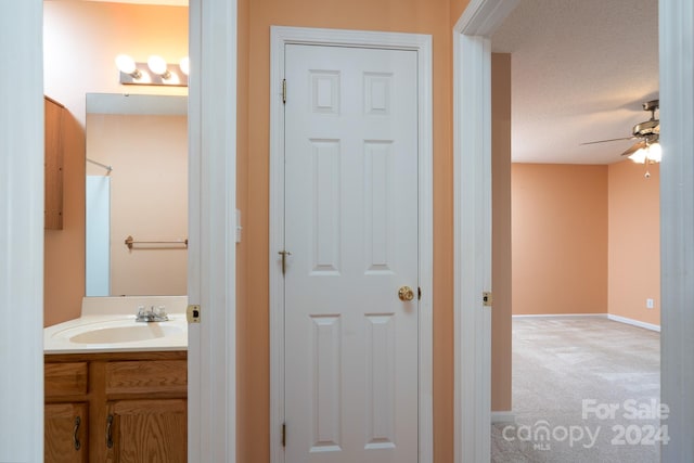 bathroom with vanity, a textured ceiling, and ceiling fan