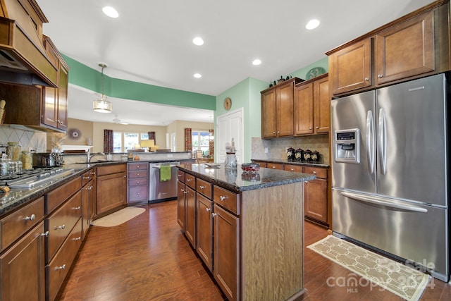 kitchen with a kitchen island, dark hardwood / wood-style flooring, kitchen peninsula, and appliances with stainless steel finishes