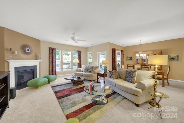 living room with ceiling fan with notable chandelier and light colored carpet