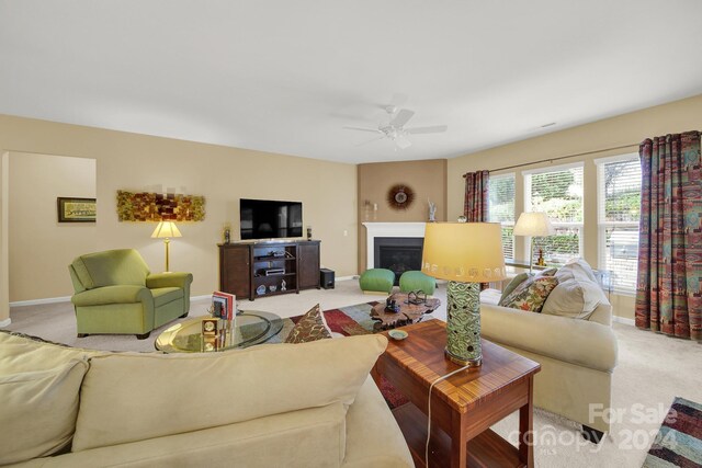 carpeted living room with ceiling fan