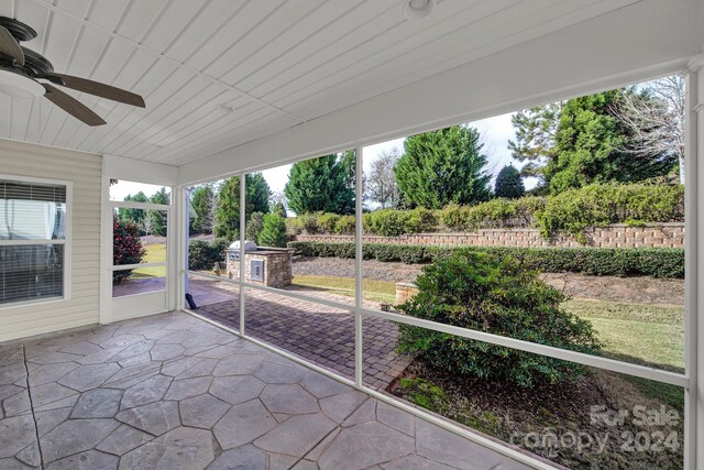 unfurnished sunroom featuring a wealth of natural light and ceiling fan