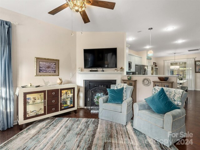 living room featuring ceiling fan and dark hardwood / wood-style flooring