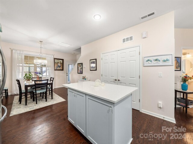 kitchen with gray cabinetry, dark hardwood / wood-style flooring, a kitchen island, and hanging light fixtures