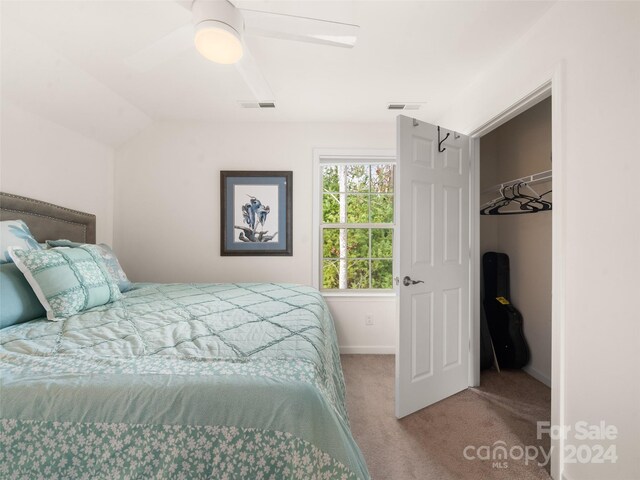 carpeted bedroom featuring ceiling fan, vaulted ceiling, and a closet