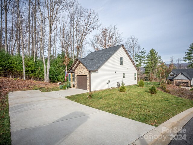 view of side of property featuring a garage and a yard