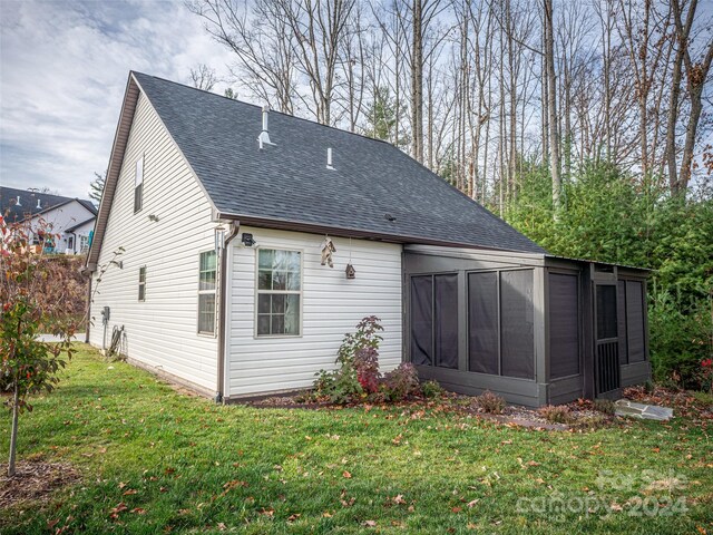 back of property featuring a sunroom and a lawn