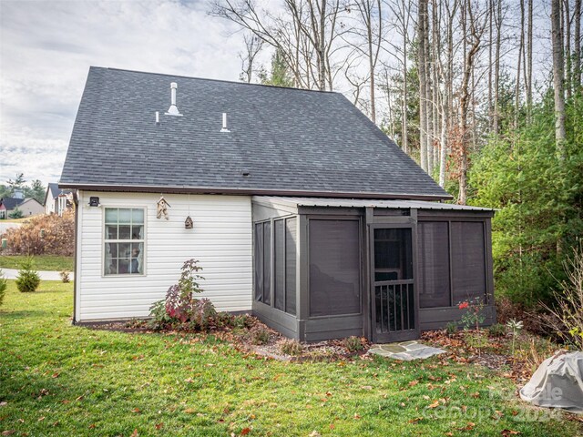 rear view of property with a sunroom and a yard