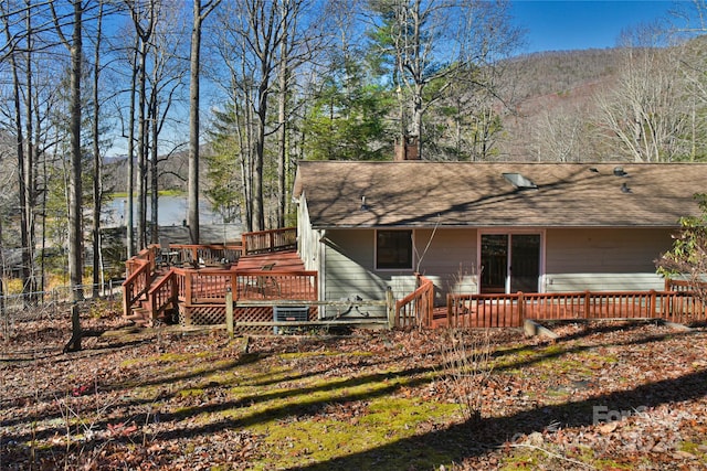 back of property featuring a deck with water view