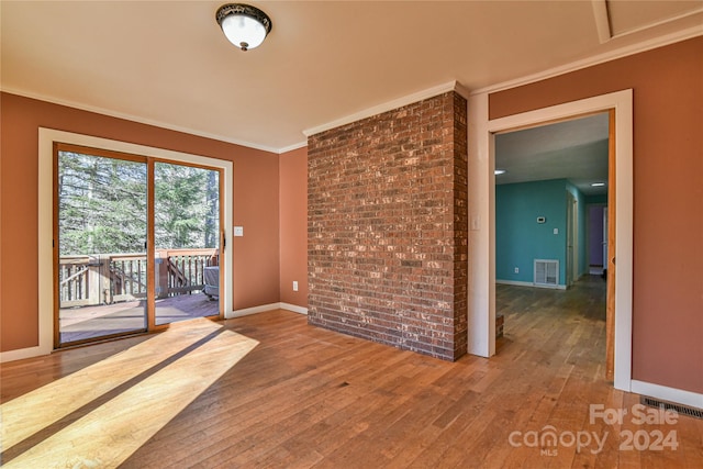 spare room with hardwood / wood-style floors and crown molding