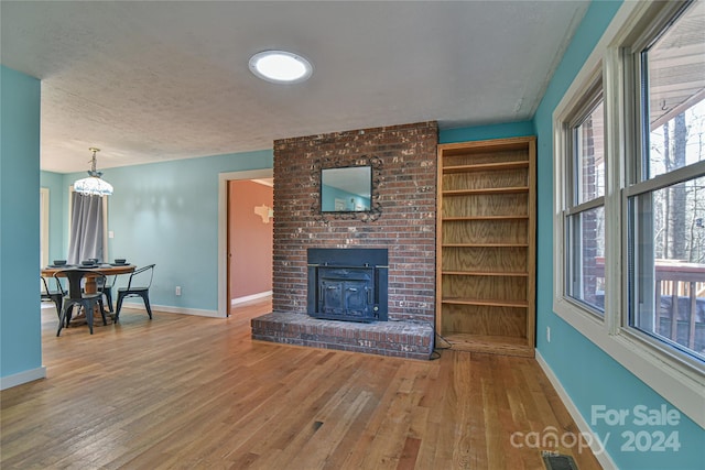 living room with a fireplace, hardwood / wood-style floors, and a textured ceiling