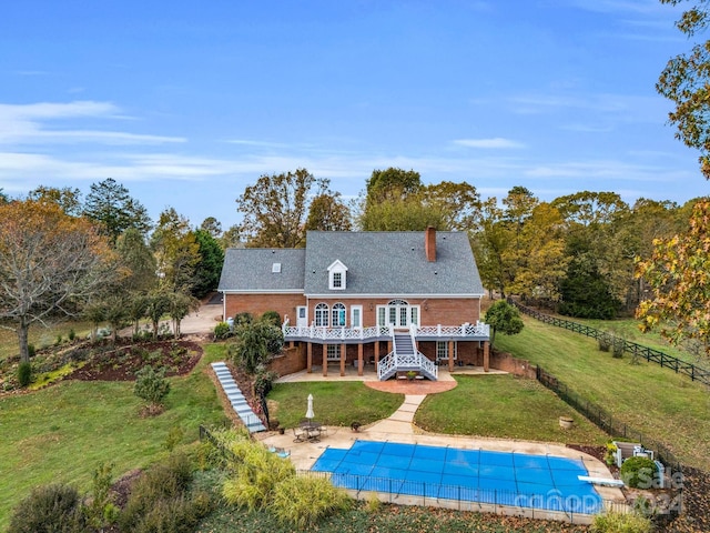 back of house with a swimming pool side deck, a yard, and a patio