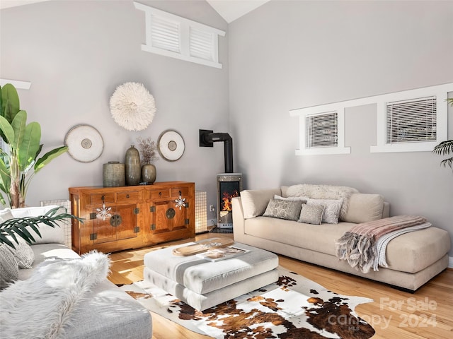 living room with a wood stove, lofted ceiling, and hardwood / wood-style flooring