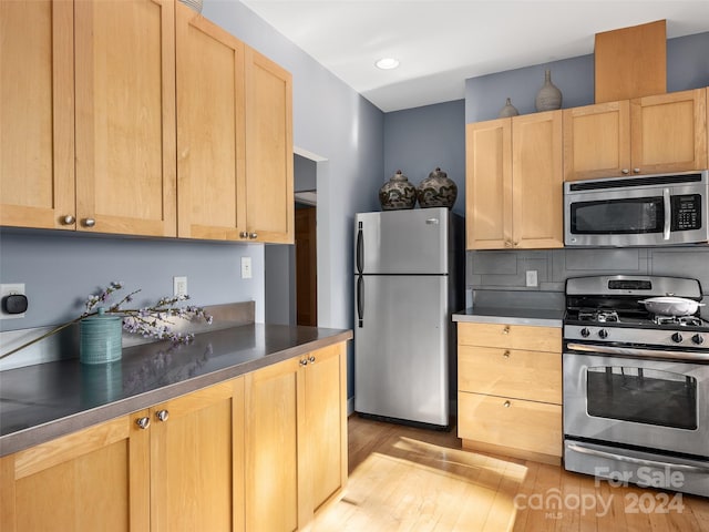 kitchen with appliances with stainless steel finishes, light wood-type flooring, and light brown cabinetry